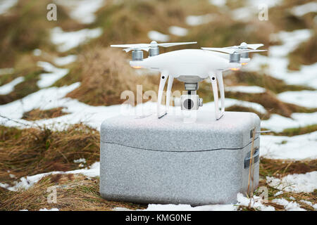 Minsk, Bielorussia - 3 dicembre 2017: dji phantom 4 pro drone soggiorno su grigio trasportare casella sul cresciuta con la neve Foto Stock