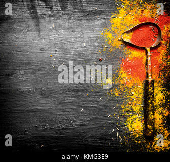 Macinate spezie indiane in un vecchio cucchiaio. sulla lavagna. Foto Stock