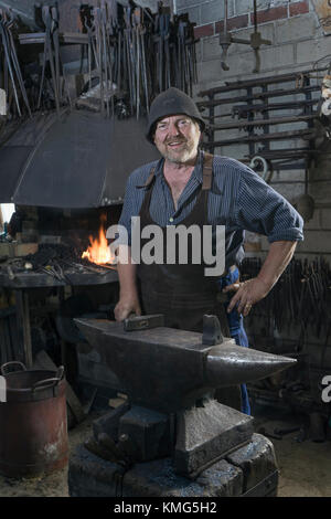 Ritratto di fabbro senior in officina tradizionale Foto Stock