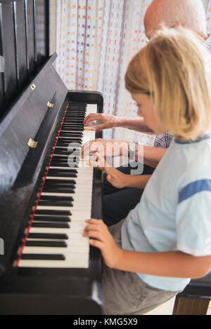 Nonno e nipote suonano strumenti a piano Foto Stock