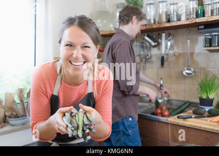 Paio di preparare il cibo, donna tenendo gli asparagi Foto Stock