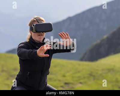 Donna che pratica il karate si muove con i vetri di realtà virtuale sulla montagna Foto Stock