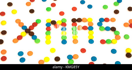 Natale parola scritta con colorate a forma di pulsante di cioccolatini candy isolati su sfondo bianco Foto Stock