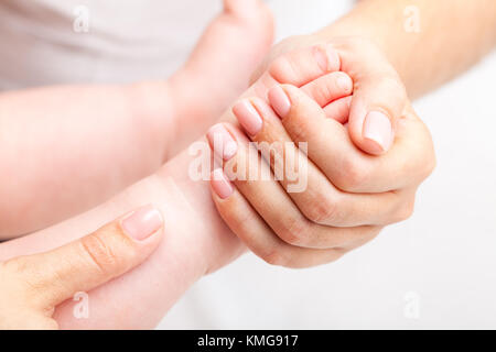 Sette mesi baby ragazze piedi giunto essendo manipolati da manuale osteopatica terapeuta o di medico Foto Stock