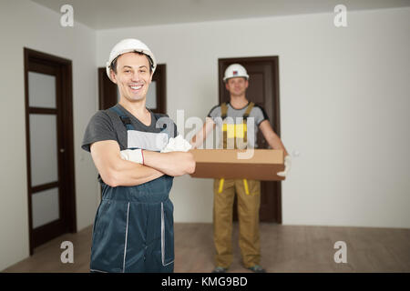 Due uomini di lavoratori in uniforme in casa pulita sfondo in camera Foto Stock