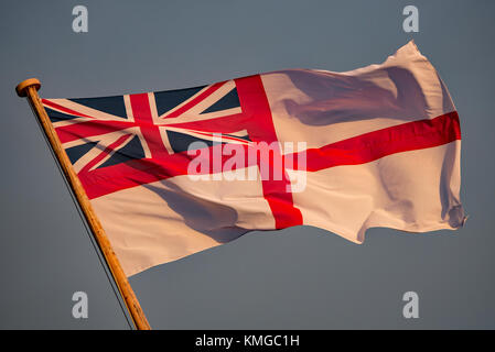 La British Royal Navy alfiere bianco a poppa della storica nave da guerra HMS Victory a Portsmouth Historic Dockyard, Regno Unito al tramonto su 7/12/17. Foto Stock