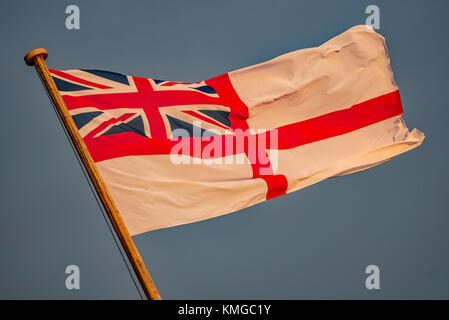 La British Royal Navy alfiere bianco a poppa della storica nave da guerra HMS Victory a Portsmouth Historic Dockyard, Regno Unito al tramonto su 7/12/17. Foto Stock