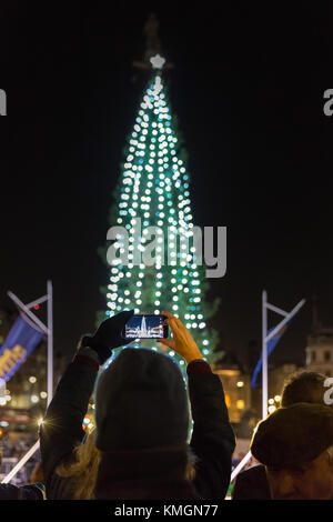Trafalgar Square, Londra, 7 dicembre 2017. Una donna prende le foto dell'albero illumunato. La cerimonia annuale dell'illuminazione dell'albero di Natale di Trafalgar Square si svolge nella piazza, con turisti e londinesi che guardano l'interruttore ufficiale, oltre a canti e canti corali in un'atmosfera festosa. L'albero di Natale di Trafalgar Square viene raccolto e donato ogni anno alla popolazione britannica dalla città di Oslo, Norvegia, dal 1947, e il 2017 è il suo 70° anniversario. Foto Stock