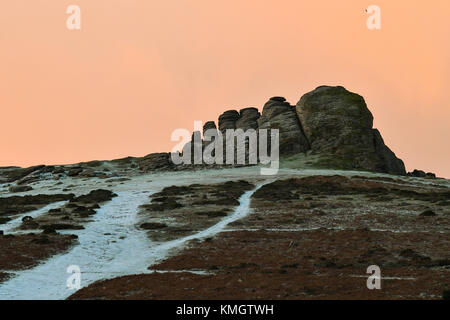 Haytor, Dartmoor, UK. 8 dicembre 2017. Regno Unito Meteo. Una leggera spolverata di neve copre il paesaggio intorno Haytor nel Parco Nazionale di Dartmoor nel Devon vicino a Bovey Tracey come le nuvole glow orrange a sunrise. Credito Foto: Graham Hunt/Alamy Live News Foto Stock