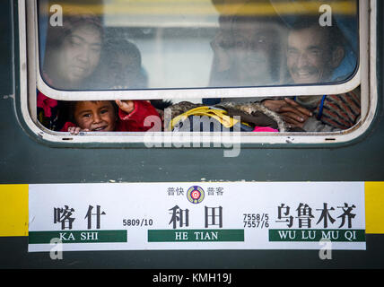 (171209) -- URUMQI, 9 dicembre 2017 (Xinhua) -- i passeggeri sono visti sul treno che collega Kashgar e Hotan nella regione Autonoma Xinjiang Uygur della Cina nord-occidentale, 25 novembre 2017. Il percorso ferroviario di 485 km che collega due grandi città oasi Kashgar e Hotan, attraversa alcune delle aree più remote dello Xinjiang e ha trasformato la vita nel deserto dal suo lancio nel 2011. È la prima e unica ferrovia di Hotan, attraverso la ferrovia la prefettura sottosviluppata è collegata al resto della rete ferroviaria del paese, che vanta 22.000 km di linee ferroviarie ad alta velocità. La scarsa infrastruttura dei trasporti ha causato Foto Stock