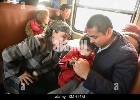 (171209) -- URUMQI, 9 dicembre 2017 (Xinhua) -- i passeggeri sono visti sul treno che collega Kashgar e Hotan nella regione Autonoma Xinjiang Uygur della Cina nord-occidentale, 25 novembre 2017. Il percorso ferroviario di 485 km che collega due grandi città oasi Kashgar e Hotan, attraversa alcune delle aree più remote dello Xinjiang e ha trasformato la vita nel deserto dal suo lancio nel 2011. È la prima e unica ferrovia di Hotan, attraverso la ferrovia la prefettura sottosviluppata è collegata al resto della rete ferroviaria del paese, che vanta 22.000 km di linee ferroviarie ad alta velocità. La scarsa infrastruttura dei trasporti ha causato Foto Stock