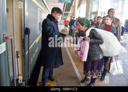 (171209) -- URUMQI, 9 dicembre 2017 (Xinhua) -- linea passeggeri per salire a bordo del treno n. 5810 che collega Kashgar e Hotan nella regione autonoma di Xinjiang Uygur, 25 novembre 2017. Il percorso ferroviario di 485 km che collega due grandi città oasi Kashgar e Hotan, attraversa alcune delle aree più remote dello Xinjiang e ha trasformato la vita nel deserto dal suo lancio nel 2011. È la prima e unica ferrovia di Hotan, attraverso la ferrovia la prefettura sottosviluppata è collegata al resto della rete ferroviaria del paese, che vanta 22.000 km di linee ferroviarie ad alta velocità. Scarse infrastrutture di trasporto Foto Stock