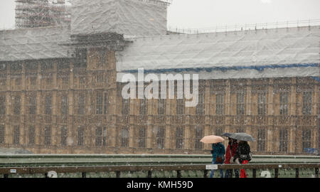 Londra, Regno Unito. Decimo Dec, 2017. La gente a piedi nella neve sul Westminster Bridge nel centro di Londra, Gran Bretagna a Dic. 10, 2017. Credito: Han Yan/Xinhua/Alamy Live News Foto Stock