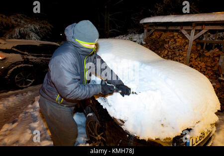 Una persona sgombero della neve auto off su di un viale di ingresso prima che il treno dopo la tempesta Caroline coperto il Galles del Nord e Flintshire nella neve Foto Stock