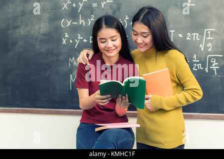 Due studenti asiatici che studiano insieme in aula in università. Studente universitario. Foto Stock