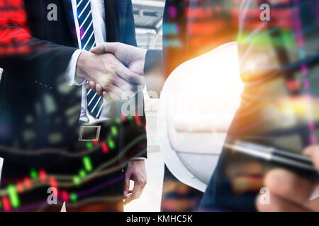 Fintech concetto tecnologico. Doppia esposizione di uomini di affari di handshake di sfocatura e mercato azionario trading grafico sullo schermo. Foto Stock