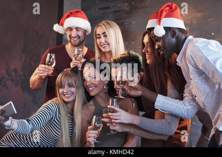 Gruppo giovane e bella gente facendo selfie nella festa di capodanno, migliori amici ragazze e ragazzi insieme divertendosi, creando uno stile di vita emotiva di persone. H Foto Stock