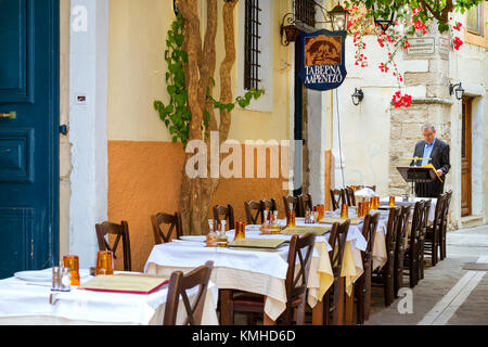 Rethymno, Grecia - 3 maggio 2016: Tavolo servito con posate nel ristorante in una stretta strada turistica. Passeggia per il centro storico di Rethymno, in Grecia. Cu Foto Stock