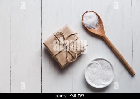 Un sano sale marino con giftbox bianco su sfondo di legno Foto Stock