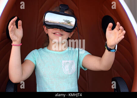 Felice bambina con la realtà virtuale della cuffia sulla testa Foto Stock