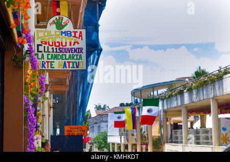 Bogotà, Colombia, 22 ottobre 2017: persone non identificate a piedi in strada 11 con alcuni flag appesi da un edificio in una bella la candelaria quartiere storico nel centro cittadino di Bogotà, Colombia Foto Stock