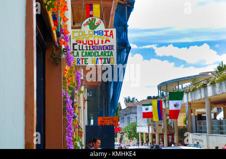 Bogotà, Colombia, 22 ottobre 2017: persone non identificate a piedi in strada 11 con alcuni flag appesi da un edificio in una bella la candelaria quartiere storico nel centro cittadino di Bogotà, Colombia Foto Stock