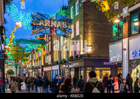 Carnaby St a Natale con decorazioni natalizie a tema tropicale, Soho, Londra, Regno Unito Foto Stock