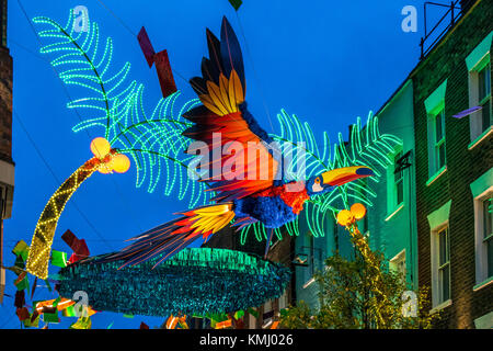 Carnaby St a Natale con decorazioni natalizie a tema tropicale, Soho, Londra, Regno Unito Foto Stock