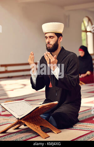 Musulmani l uomo e la donna che prega per Allah nella moschea insieme Foto Stock