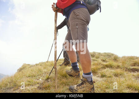 Close-up di gambe di giovani escursionisti a piedi sul percorso del paese. Coppia giovane trail veglia. Focus su scarpe da escursionismo Foto Stock