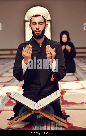 Musulmani l uomo e la donna che prega per Allah nella moschea insieme Foto Stock