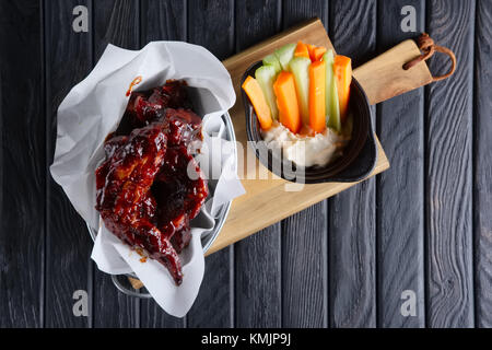 Snack per la birra. ALI DI POLLO PICCANTI con un fresco e la carota e il sedano e salsa Foto Stock