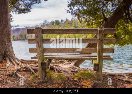 Ambiente sereno, una panca parco che si affaccia su un lago tranquillo. Green Lakes, Syracuse, New York Foto Stock