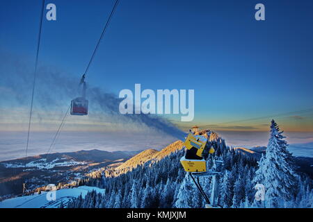 Cannoni da neve in azione sulle piste da sci resort in Poiana Brasov Romania Foto Stock