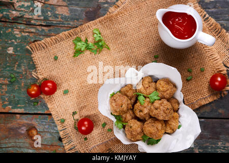 Tritate il pesce fritto sfere con il cetriolo cressl su uno sfondo bianco con salsa chili . Il fuoco selettivo Foto Stock