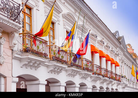 Quito, Ecuador Novembre, 28, 2017: Bellissimo edificio bianco con alcuni glags appesi da un balcone al centro storico della città vecchia di Quito in Ecuador settentrionale nelle montagne delle Ande Foto Stock