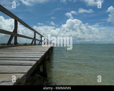 Passerella in legno del molo sulle calme acque della baia con cielo blu e le nuvole sul Golfo del Messico a Rockport, Texas Foto Stock