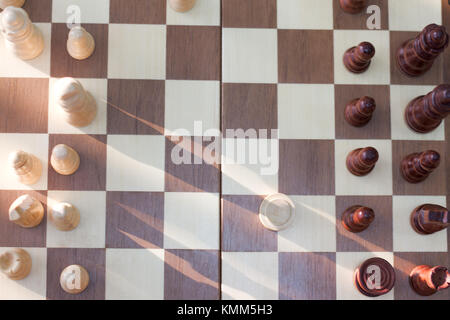 Una foto di una scacchiera e pezzi di scacchi, scacchi in legno pezzi su una scacchiera Foto Stock
