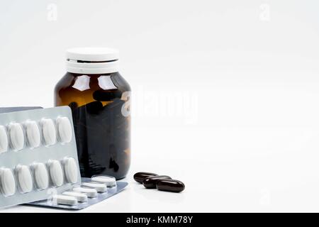 Vitamine capsula in vetro ambrato con etichetta vuota e supplementi compresse in blister su sfondo bianco. Buona supplemento pillole per donna b Foto Stock