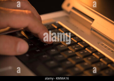 L'uomo premendo un tasto sulla tastiera del notebook Foto Stock