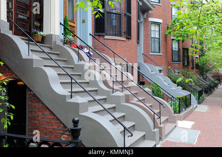 South End di Boston, fila vittoriano case. brick appartamento edifici e marciapiedi, passi colorati con pietra ondulata trim, ringhiere in ghisa e recinti, ONU Foto Stock