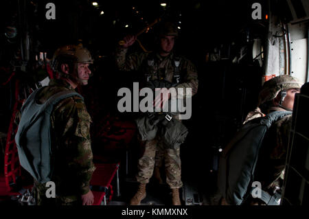 Staff Sgt. Stephen West, un jumpmaster con il 18 Airborne Corp, centro, si prepara a paracadutare un C-130 come gli Stati Uniti e colombiani Jumpmaster garantire che è sicuro per uscire l'aereo durante il salto lottery di operazione Toy Drop a Fort Bragg, N.C., 2 dicembre 2017. Operazione Toy Drop è il più grande esercizio combinato di addestramento aereo e collettivo del mondo con sette paracadutisti della nazione partner che hanno partecipato e hanno permesso ai soldati di aiutare i bambini bisognosi a ricevere giocattoli per le vacanze. (STATI UNITI Esercito Foto Stock