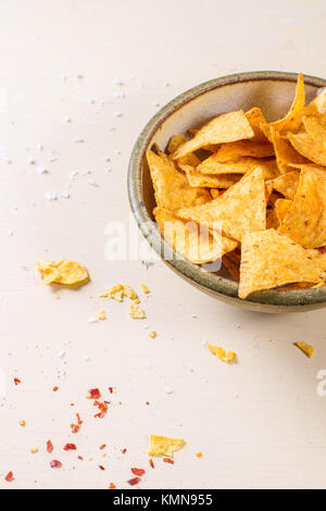 Ciotola di mais nachos chips su bianco sullo sfondo di legno. Foto Stock