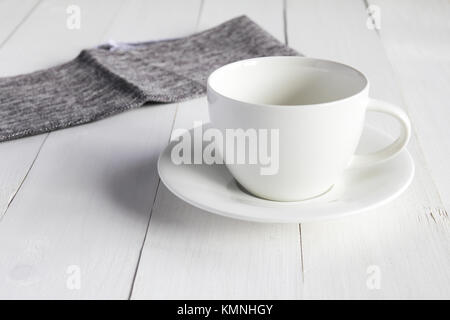 Svuotare la coppa di bianco su bianco tavolo in legno. Foto Stock