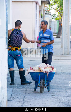 L'uomo la vendita di carne di maiale da una carriola in Cienfuegos, Cuba Foto Stock