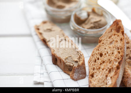 Pane con carne di vitello e patè di coniglio con burro su un sfondo di materie tessili. Foto Stock