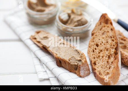 Pane con carne di vitello e patè di coniglio con burro su un sfondo di materie tessili. Copia dello spazio. Foto Stock