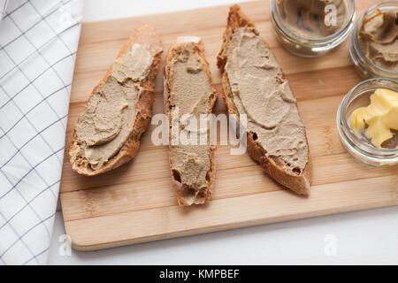 Pane con carne di vitello e patè di coniglio con burro su una scheda di bambù. Foto Stock