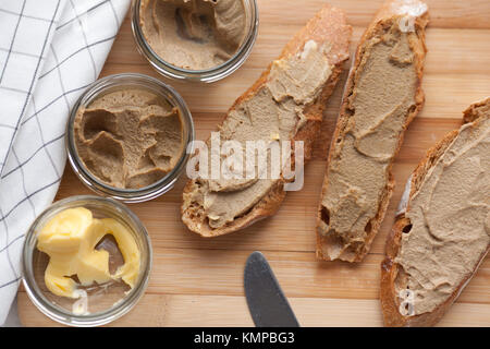 Pane con carne di vitello e patè di coniglio con burro su una scheda di bambù. Vista dall'alto. Foto Stock