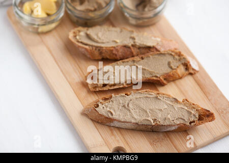 Pane con carne di vitello e patè di coniglio con burro su una scheda di bambù. Foto Stock